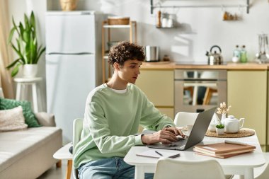 Odaklanmış genç bir adam, özel bir ofiste dizüstü bilgisayarına yazar..