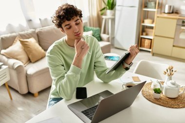 Yakışıklı bir genç adam şık bir dairede otururken işine odaklanır ve verimli bir günün tadını çıkarır..