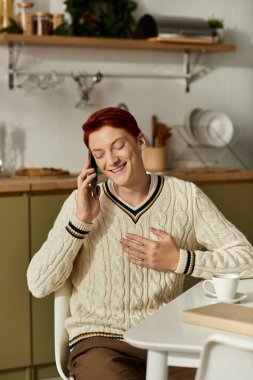 Keyifli, genç bir adam Noel 'de telefonda konuşurken gülüyor..