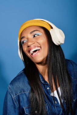 Genç kadın, sonbahar katmanları ve canlı renkler içinde müziği kucaklarken neşe saçıyor..