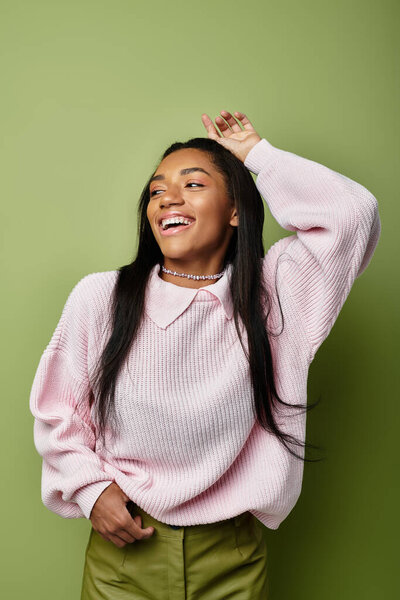 Молодая женщина излучает радость в своем уютном розовом свитере, обнимая осенние вибрации.