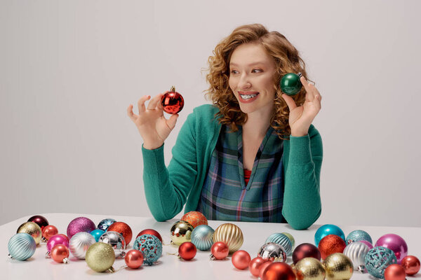 Веселая молодая женщина наслаждается позируя с яркими украшениями вокруг нее.