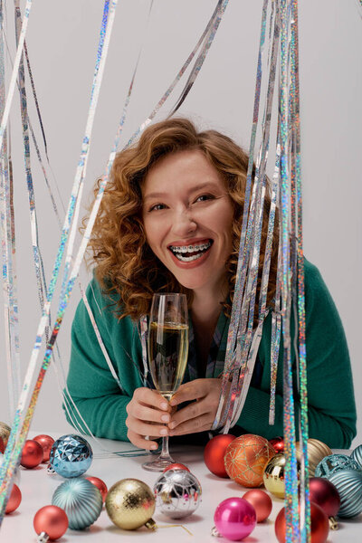 The young woman happily posing cheerfully while surrounded by festive decorations and ornaments.