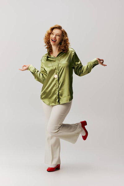 Веселая молодая женщина с игривой стойкой и яркой улыбкой.