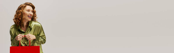 Молодая женщина с кудрявыми волосами с энтузиазмом позирует, распространяя праздничное настроение.