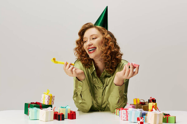 Молодая женщина радостно позирует в шляпе для вечеринок.