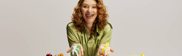A young woman expresses happiness while posing in vibrant paper and ribbons.