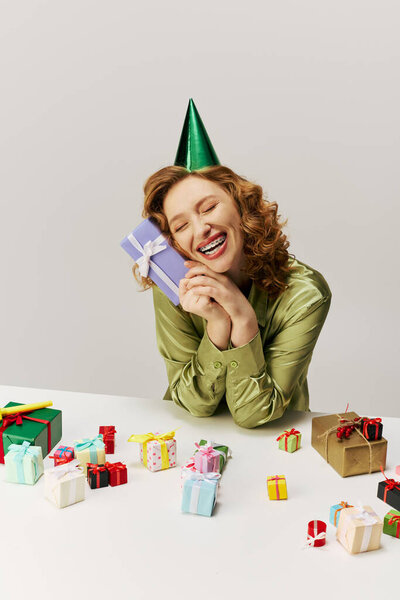 The young woman enjoys posing while surrounded by various presents.