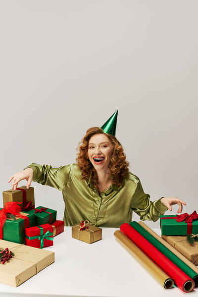 A delighted young woman in green joyfully posing for an upcoming festive occasion.