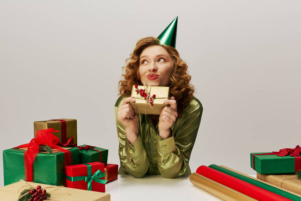 A young woman playfully posing while wearing a party hat, embracing the festive spirit.
