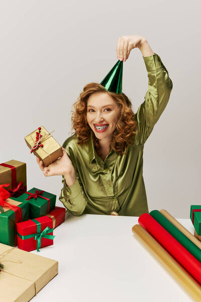 A cheerful young woman enjoys posing with colorful decorations in a festive setting.