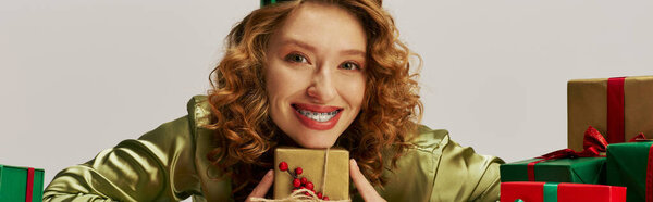 Молодая женщина взволнованно позирует среди ярко украшенных коробок.