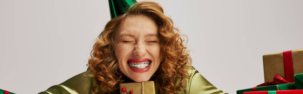 A young woman wearing festive clothing smiles brightly while posing.