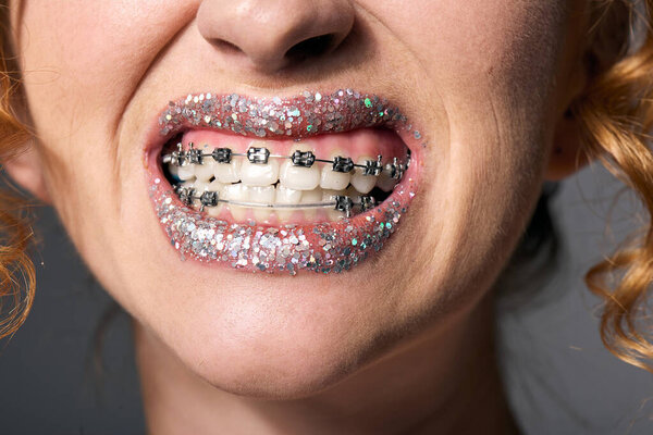 A young woman joyfully posing cheerfully in colorful paper and ribbons, brightening the day.