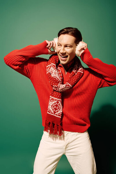 A young man exudes happiness as he playfully poses, showcasing his vibrant fashion choices.