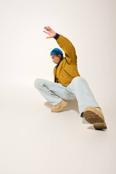 A young man showcases his unique style and enthusiasm with vibrant tattoos in a striking pose.
