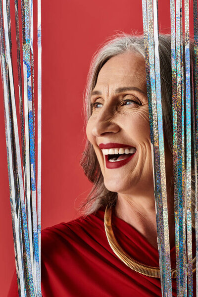 Красивая зрелая женщина с седыми волосами радостно светится, празднуя праздничный дух Рождества и Нового года.