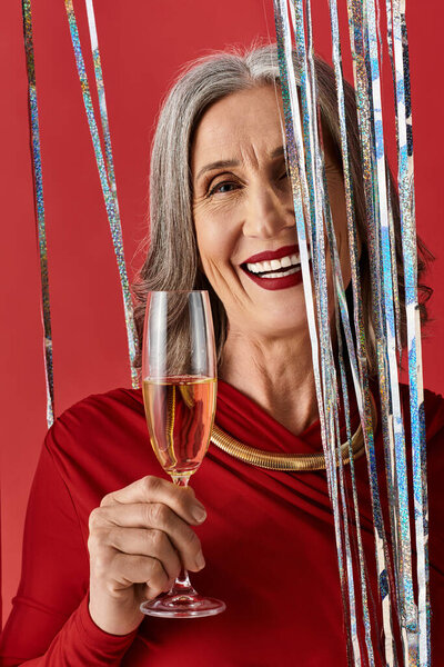 Светлая зрелая женщина с седыми волосами наслаждается тостом, празднуя Рождество и Новый год в стиле.