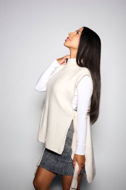 Genç bir kadın şık bir ortamda kendine güvenle yukarı bakar..