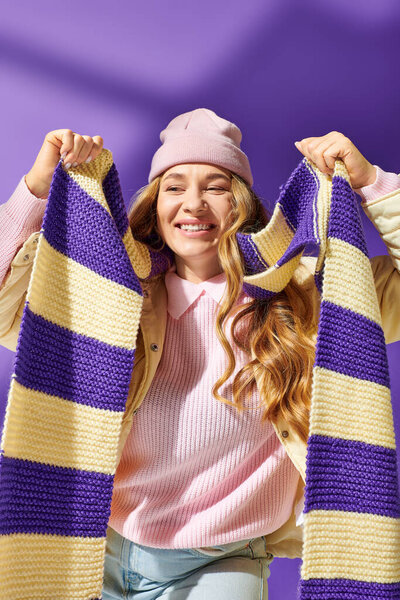 A young beautiful plus size woman happily displays her handmade scarf while smiling joyfully.
