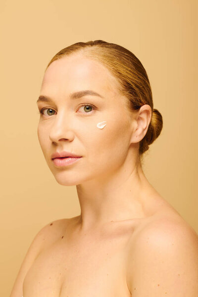 Молодая красивая женщина плюс размер мягко со сливками на щеке, глядя в камеру.