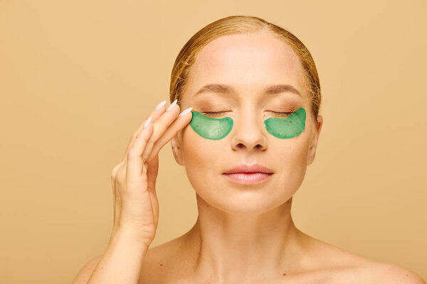 Молодая женщина плюс размер любит уход за собой, применяя зеленые пятна под глазами.