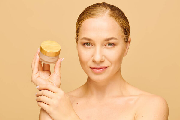 A joyful young woman showcases her favorite skincare product in a soft, inviting ambiance.