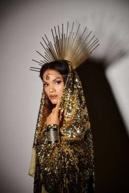 Parlak, altın rengi elbisesi olan zarif bir Afrikalı Amerikalı kadın çarpıcı duruşu ve zarafetiyle büyülüyor..