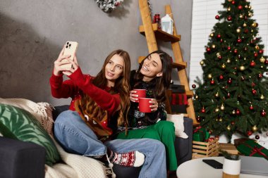 Evde tatil sezonunu kutlarken rahat kazaklı iki kız arkadaş birbirine eşlik ediyor.