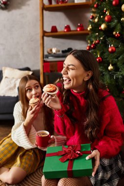 Kız arkadaşlar evde tatil ruhunu kutlarken keyifli anları, ikramları ve sıcak içecekleri paylaşırlar..