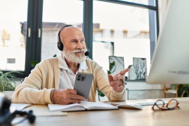 Çağdaş bir ofiste çalışırken sakallı şık bir kıdemli işadamı telefonla iletişim kuruyor..
