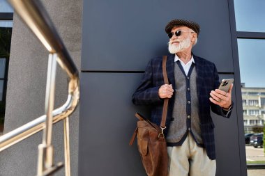 Şık bir son sınıf öğrencisi, güz tarzını sergilemek için çağdaş bir binanın önünde duruyor..
