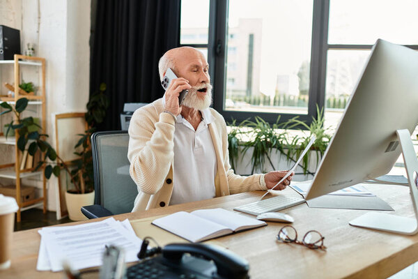 Старший бизнесмен в нарядной повседневной одежде усердно работает, управляя звонками и документами в ярком офисе.