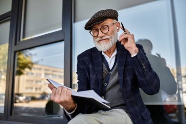 Şık bir bina tarafından sonbaharın renklerine bürünmüş, sakallı şık bir son sınıf öğrencisi özenle çizimler yapıyor..