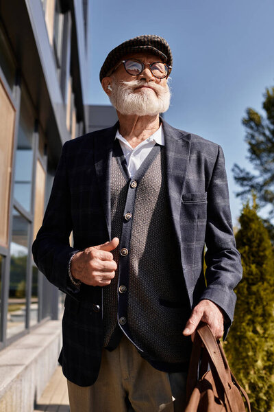 A fashionable senior man strolls confidently in smart casual attire, embracing the autumn ambiance.