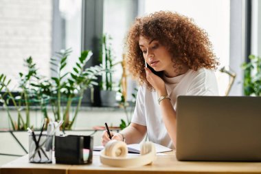 A thoughtful woman sits at a desk, pen in hand, immersed in her work within a sunny workspace. clipart