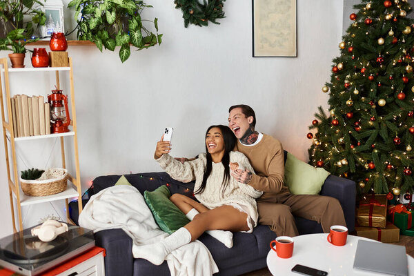 Пара наслаждается сердечным моментом вместе, делая селфи среди праздничных украшений.