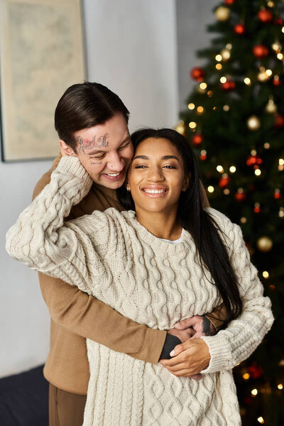 A loving couple enjoys a warm moment together, surrounded by festive Christmas decorations.