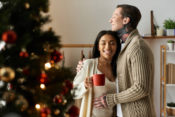 Пара разделяет любящий момент дома, окруженный рождественскими украшениями и радостью.