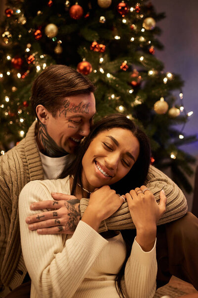 A couple shares laughter and warmth while celebrating Christmas in their beautifully decorated home.