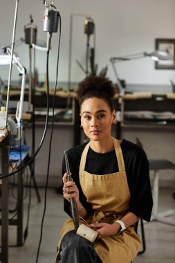 Yetenekli bir kadın, sanatını sergilemek için mücevher yapma stüdyosunda özenle çalışır..