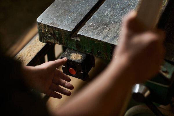 A female carpenter focuses on her work, expertly handling tools in a warm and inviting wood workshop.