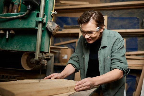 A skilled carpenter attentively shapes wood with precision tools in a lively workshop environment.
