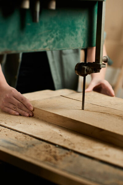 A determined female carpenter carefully works on shaping wood in a well-lit workshop, showcasing her skills.