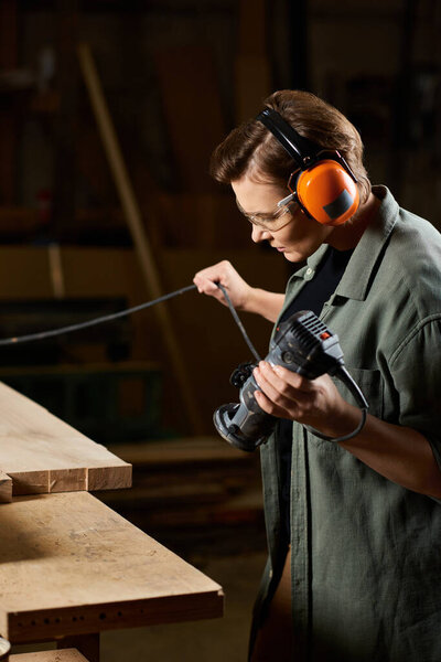 A dedicated carpenter expertly uses a power tool while shaping wood in her workshop, highlighting her craftsmanship.