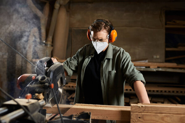 A dedicated carpenter engages with a saw, meticulously crafting wood in her vibrant workshop.