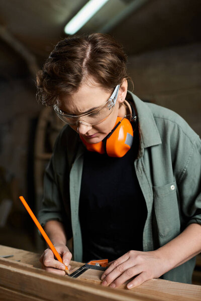 A dedicated female carpenter works meticulously in her workshop, measuring wood with careful concentration.