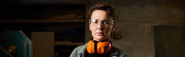 A dedicated female carpenter works on her project in a bright, well-equipped workshop.
