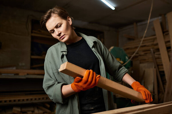 A skilled female carpenter focuses intently on her woodworking project while surrounded by tools and materials.