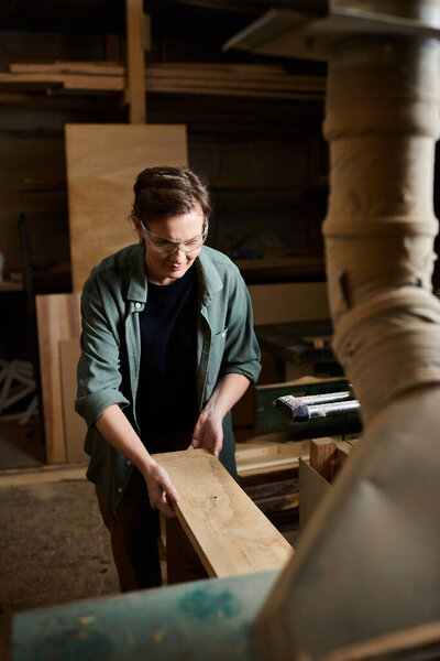 Самоотверженная плотница тщательно работает с деревом, демонстрируя свое мастерство в оживленной мастерской..